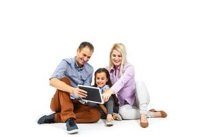 familia utilizando digital tableta ordenador portátil foto