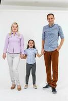 Happy young family with pretty child posing on white background photo