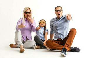 Frightened attractive family wearing casual outfit isolated over white background, watching a movie with 3d glasses photo