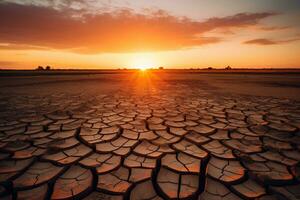 Stunning sunset over a dried out field. The golden sun casts a warm glow over the cracked earth, creating a dramatic and beautiful scene. Generative AI photo