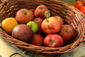 mimbre cesta con Fresco maduro rojo manzanas y uno verde tomate foto