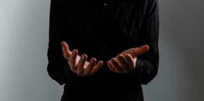 Handsome man sit prayer on black background. His hands are praying for God's blessings. photo