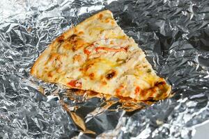 last old piece of pizza on foil photo