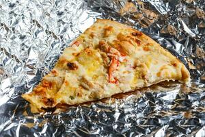 Last food piece of popular pizza on foil photo