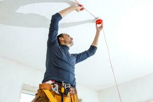 Electrician installing fire alarm system indoors photo