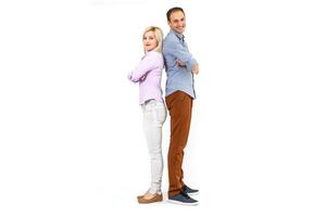 Smiling young couple embracing and standing full length isolated on white background photo