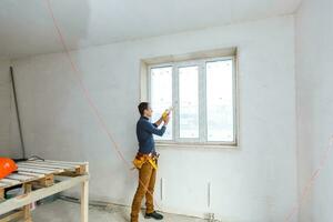 Construction worker installing window in house photo