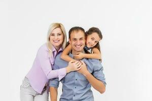 Happy young family with pretty child posing on white background photo