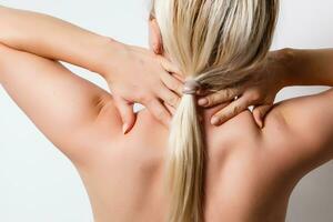 Woman with pain in her neck and shoulder, Isolated medical shot over white background. photo