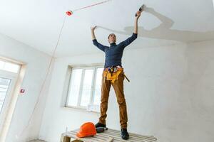 Mature contractor plasterer working indoors photo