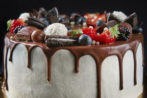 Cake decorated with strawberry and chocolate on dark background photo