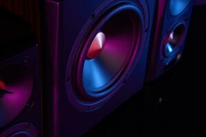 Two sound speakers and subwoofer on dark background with neon lights photo