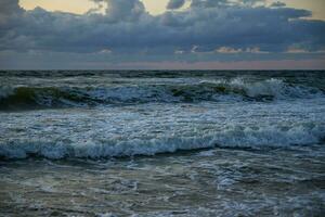 Baltic sea against dramatic cloudy sky at sunset photo