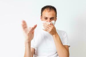 Closeup portrait of young man, disgust on his face, pinches his nose looks away, something stinks, very bad smell, situation, isolated on white background. Negative emotion facial expression feeling photo