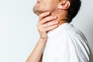 Sore throat of a men. Touching the neck. Red dot photo