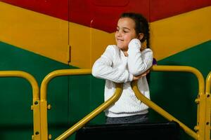 un pequeño niña cerca un grande tren carro foto