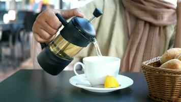 vrouw hand- giet thee van een theepot in een kop video
