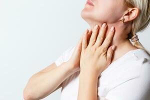 Woman suffering from sore throat. photo