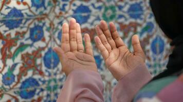 Muslim young woman in hijab is praying in mosque. video