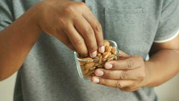 Cerca de nueces de almendras en la mano del hombre. video