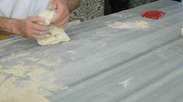 the chef's hands form a round pizza base from the dough with his hands. video