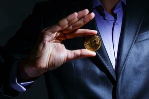 Golden Bitcoin in a man hand, Digitall symbol of a new virtual currency photo