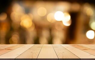 Empty wooden table top with lights bokeh on blur restaurant background photo