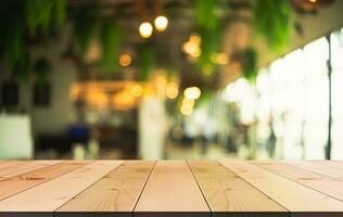 Empty wooden table top with lights bokeh on blur restaurant background photo
