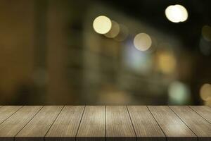 Empty wooden table top with lights bokeh on blur restaurant background. photo