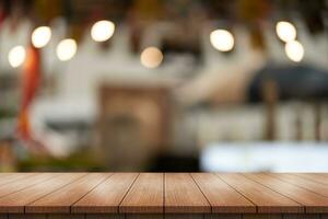 Empty wooden table top with lights bokeh on blur restaurant background. photo