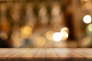 Empty wooden table top with lights bokeh on blur restaurant background. photo