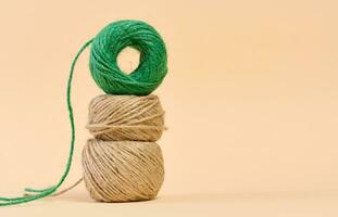 Skein of green and brown thread on a beige background photo