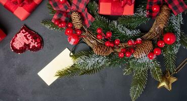 Christmas wreaths, fir branches and gifts on a black background. View from above photo