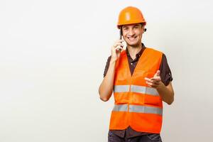 Architect on the phone and protective helmet isolated on white photo