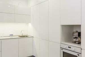 internal shot of a modern kitchen in foreground the water tap and kitchen sink photo