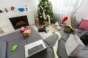 Messy living room interior with Christmas tree. Chaos after party photo
