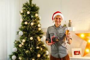 Smiling man opening Christmas gifts at home photo