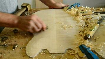 Luthier sanding a guitar with a little woodplaner video