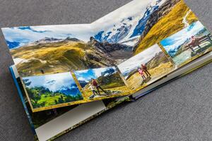 Photobook album on deck table with travel photos