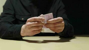 an unknown man holds a bill of five hundred euros in his hands, turns it over, examines and hands it to the viewer. High quality FullHD footage video