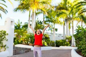 little girl walks near palm trees, vacation photo