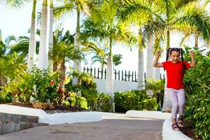 The concept of family happiness and children in the summer on the sea among palm trees. Cute little girl without a pattern. photo