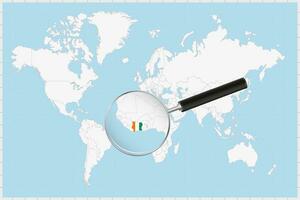 Magnifying glass showing a map of Ivory Coast on a world map. vector