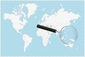 Magnifying glass showing a map of Palau on a world map. vector