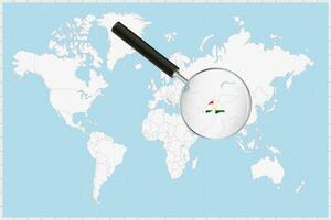 Magnifying glass showing a map of Tajikistan on a world map. vector