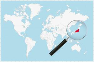 Magnifying glass showing a map of Japan on a world map. vector