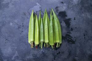 Fresh organic vegetables Lady's Finger or Okra on the Dark concrete floor photo