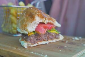 hamburguesa de ternera medio comida en la mesa de cerca foto