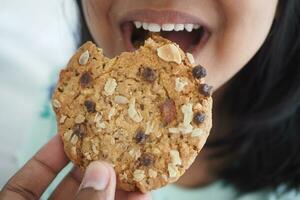 closeup of child mouth eating whole meal cookies photo