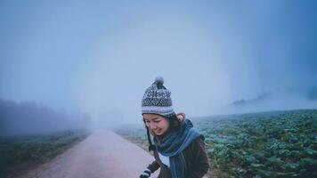 Asian women relax in the holiday. Happy to travel in the holiday. During the foggy winter photo